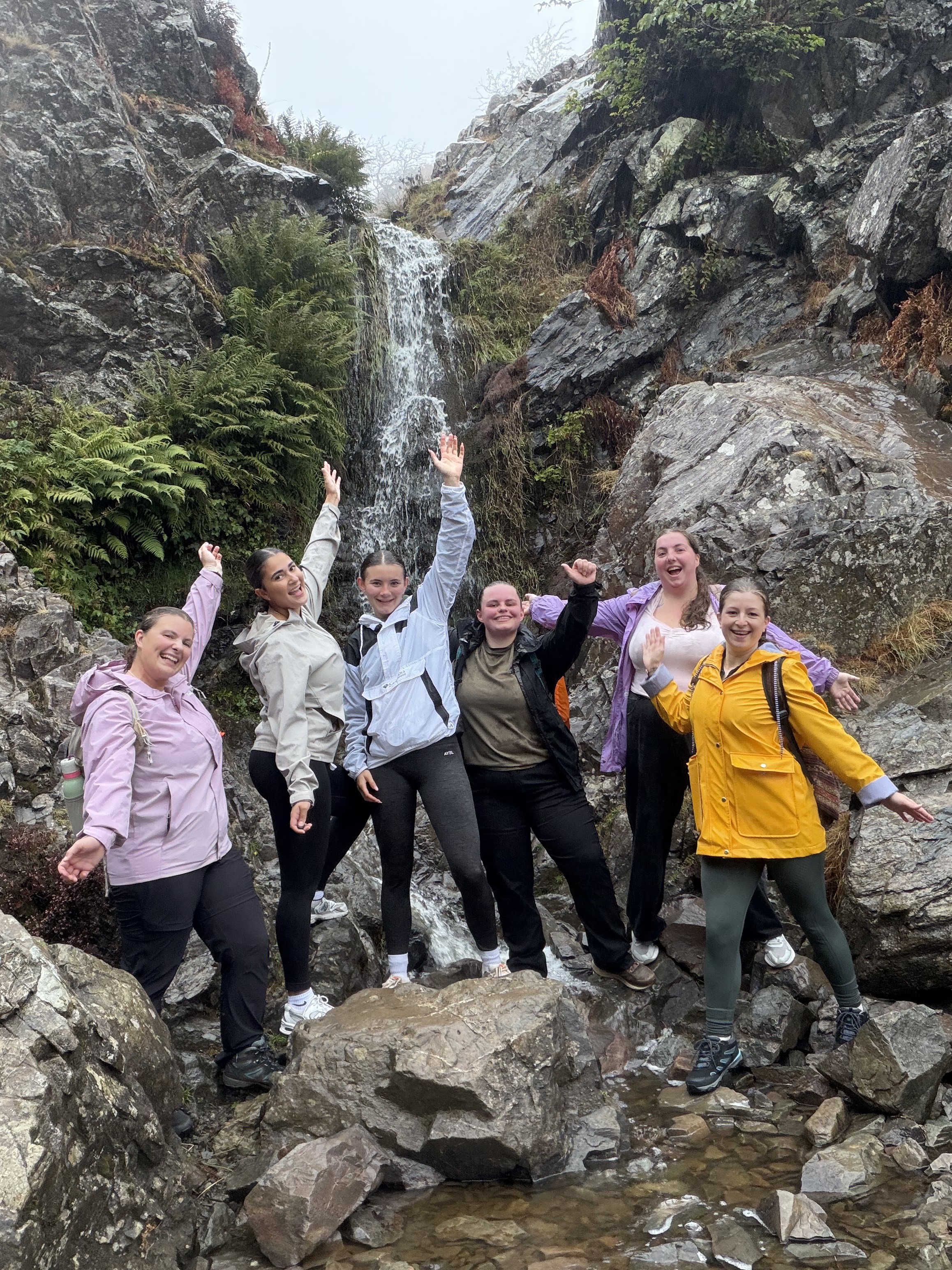The group celebrating beside a waterfall
